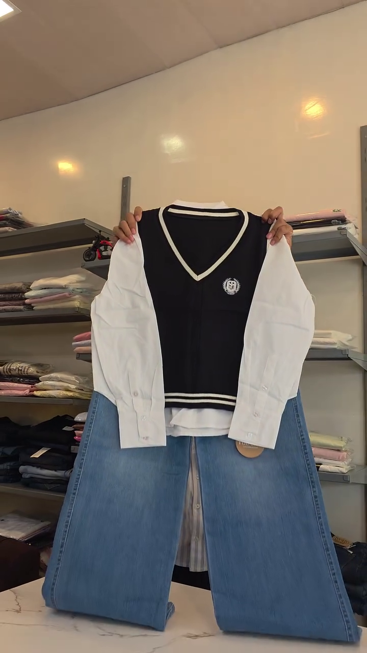 Women’s Trendy Navy Sleeveless V-Neck Sweater Vest Layered Over White Button-Down Shirt with Light Blue Wide-Leg Denim Jeans for Stylish Preppy Casual Co-Ord Fashion